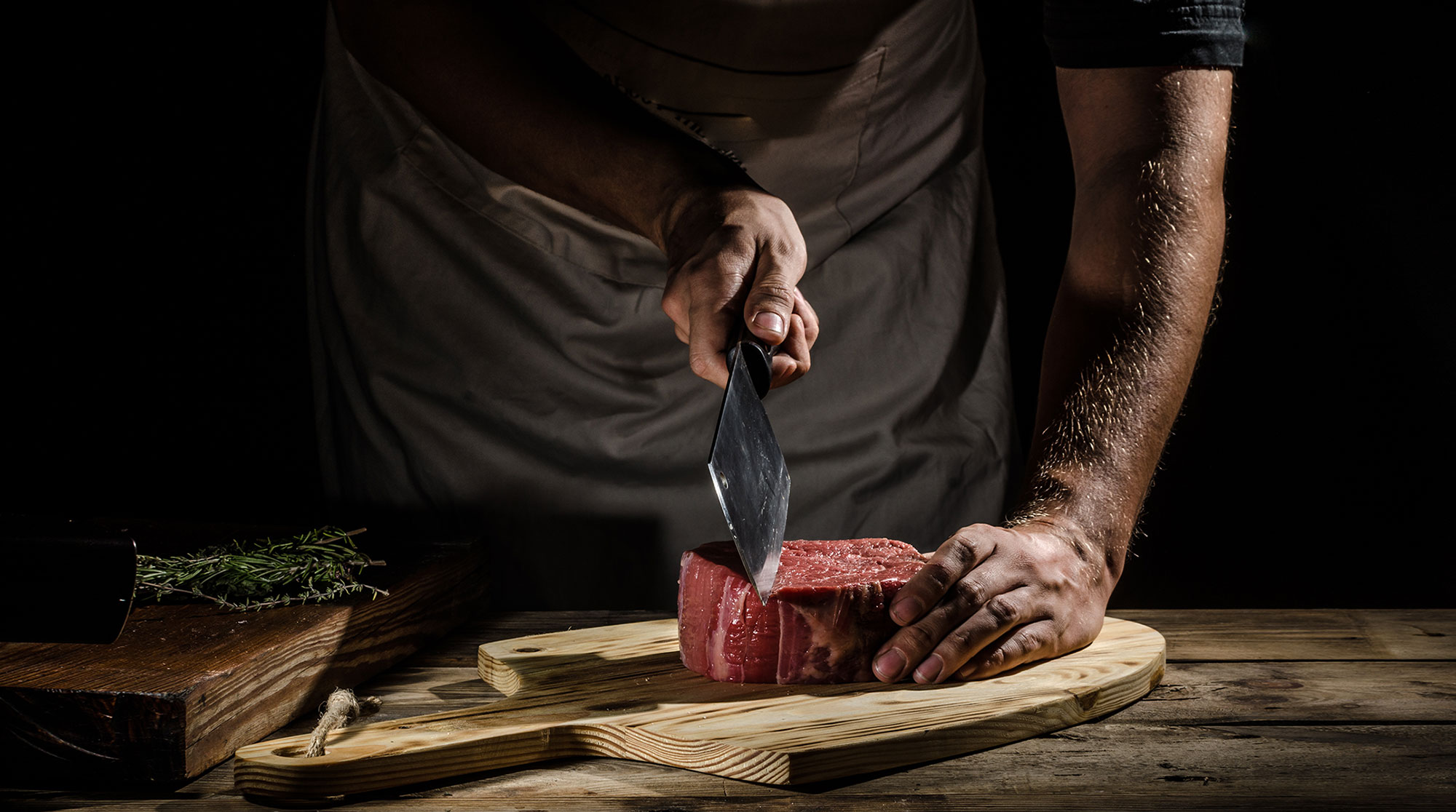 butcher cooking steak